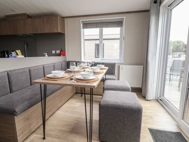 A dining area with a table set for a meal at Cedar Lodge 3 Bedrooms with hot tub Delamere