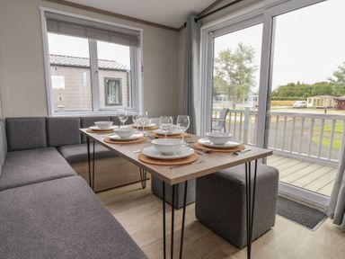 A dining area with a table set for meals at Cedar Lodge 3 Bedrooms with hot tub Delamere