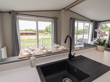 A kitchen with a black sink and dining setup at Cedar Lodge 3 Bedrooms with hot tub Delamere