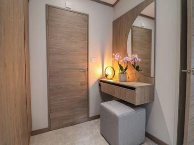 A hallway with a mirror and flower pot at Cedar Lodge 3 Bedrooms with hot tub Delamere
