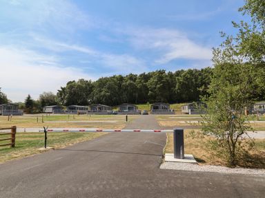 A view of a holiday park with huts and a barrier at Cedar Lodge 3 Bedrooms with hot tub, Delamere