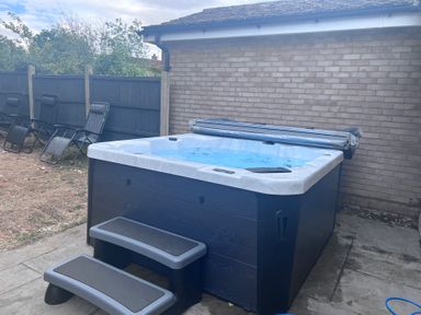 A hot tub with steps beside lawn chairs at 43 Goose Green Road King's Lynn