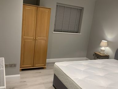 A bedroom with a wardrobe and a bed at 43 Goose Green Road in King's Lynn