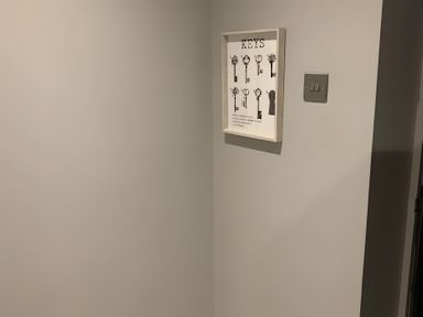 A wall with framed key artwork and light switch at 43 Goose Green Road King's Lynn