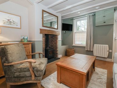 A living room with a fireplace and armchair at No.4 Main Street in Hull