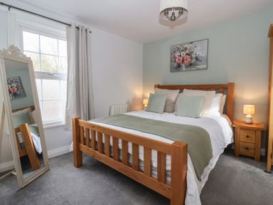 A bedroom with a bed and a mirror at No.4 Main Street in Hull