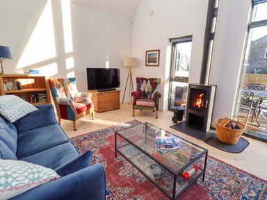 A living room with a sofa and television at 1 Dairy Fields Longframlington