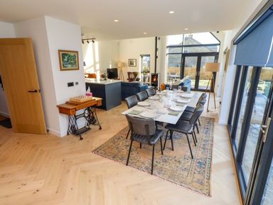 A dining room with a long table set for dinner at 1 Dairy Fields Longframlington