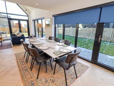 A dining room with a table set for a meal at 1 Dairy Fields Longframlington