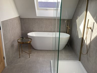 A bathroom with bathtub and shower at The Barn in Longframlington
