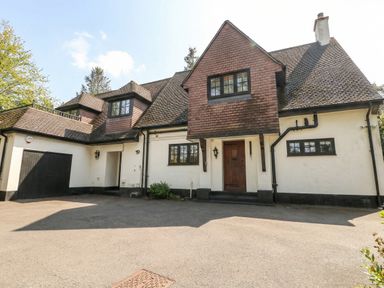 A house with a garage and garden at Woodlands house in Ringwood