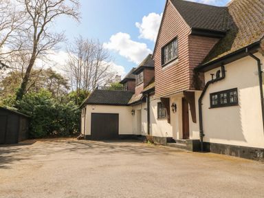 A house with a garage and driveway at Woodlands house in Ringwood