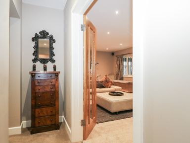 A living room entrance with a mirror and chest of drawers at Woodlands house Ringwood