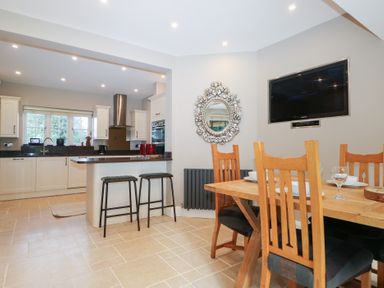 A kitchen with a dining area and appliances at Woodlands house in Ringwood