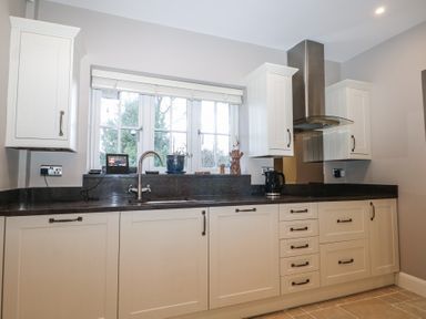 A kitchen with cabinets and sink at Woodlands house in Ringwood
