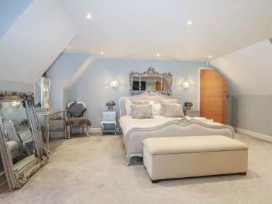 A bedroom with a bed and mirror at Woodlands house in Ringwood