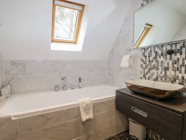 A bathroom with a bathtub and sink at Woodlands house in Ringwood