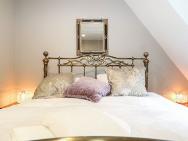 A bedroom with a bed and side lamps at Woodlands house Ringwood