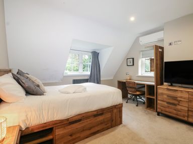 A bedroom with a bed and desk at Woodlands house Ringwood