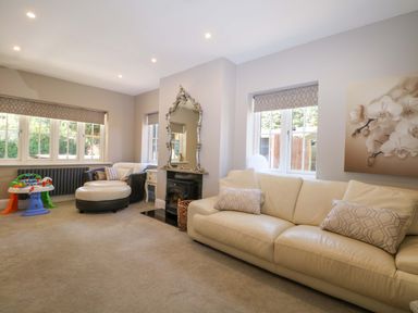A living room with a sofa and armchair at Woodlands House in Ringwood
