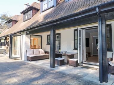 An outdoor seating area with furniture at Woodlands House in Ringwood
