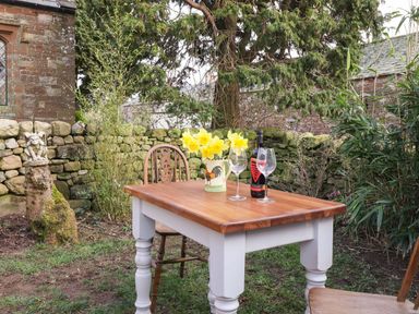 A table with wine glasses and flowers in a garden at Dunfell Shepherd's Hut Appleby-In-Westmorland