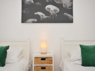 A bedroom with two beds and a nightstand at Cribba in Port Isaac