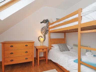 A bedroom with a bunk bed and a chest of drawers at Cribba in Port Isaac
