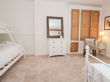 A bedroom with a bunk bed and dresser at No.2 The Flags, Grange-over-Sands