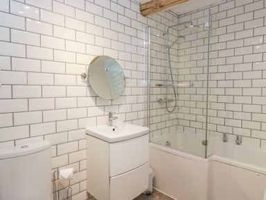 A bathroom with a sink, mirror, shower, and bath at No.2 The Flags, Grange-over-Sands
