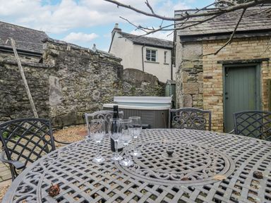 An outdoor patio with a table and chairs at No.2 The Flags Cartmel