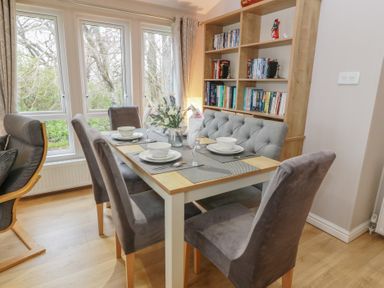 A dining room with a table and chairs at Serenity Lodge in Wemyss Bay