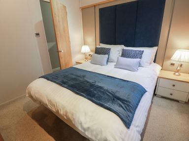 A bedroom with a bed and bedside lamps at Serenity Lodge in Wemyss Bay