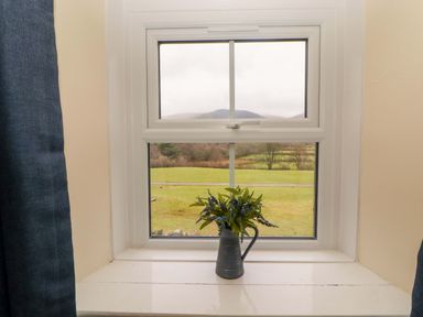 A window with flowers on the sill at Easthwaite Cottage in Holmrook near Easthwaite Farm