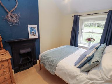 A bedroom with a bed and fireplace at Easthwaite Cottage in Holmrook near Easthwaite Farm