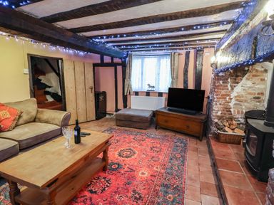 A living room with a sofa and television at Driftway Cottage in Diss