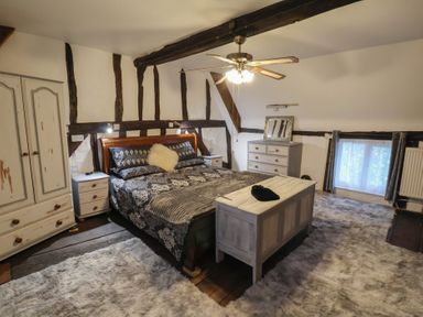 A bedroom with a bed and nightstands at Driftway Cottage in Diss