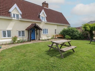 A garden with a house and outdoor seating at Driftway Stables Retreat, Diss