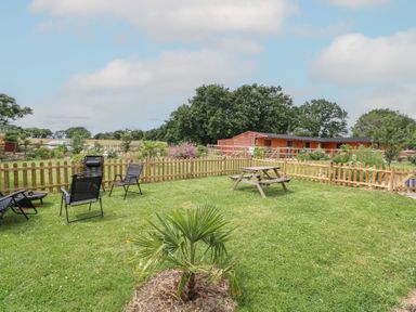 A garden with chairs and a picnic table at Driftway Stables Retreat in Diss