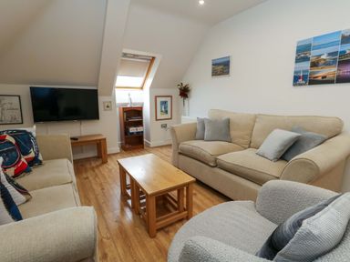 A living room with a sofa and television at Flat 7 in Weymouth