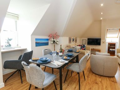 A dining room with a table set for dinner at Flat 7 in Weymouth