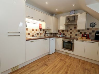 A kitchen with cabinets, sink, and oven at Flat 7 Weymouth