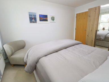 A bedroom with a bed and an armchair at Flat 7 Weymouth