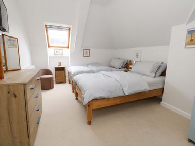 A bedroom with two beds and a dresser at Flat 7 in Weymouth