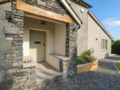 The entrance with a stone wall and front door at Low House Cottage Ayside near Newby Bridge