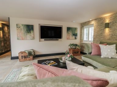 A living room with a television and seating area at Low House Cottage Ayside near Newby Bridge