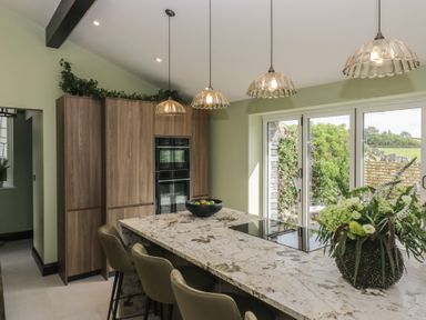 A kitchen with an island and bar stools at Low House Cottage Ayside near Newby Bridge