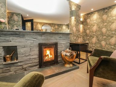 A living room with a fireplace and seating area at Low House Cottage Ayside near Newby Bridge