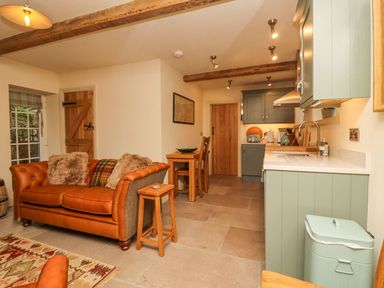 A kitchen with a sofa and dining area at Bridge House Cottage Burn Bridge near Harrogate