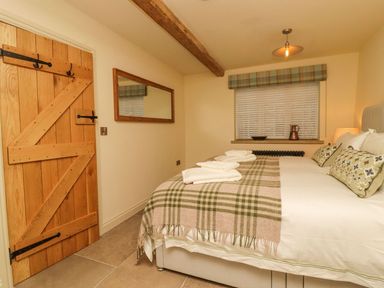 A bedroom with a bed and decorative items at Bridge House Cottage Burn Bridge near Harrogate